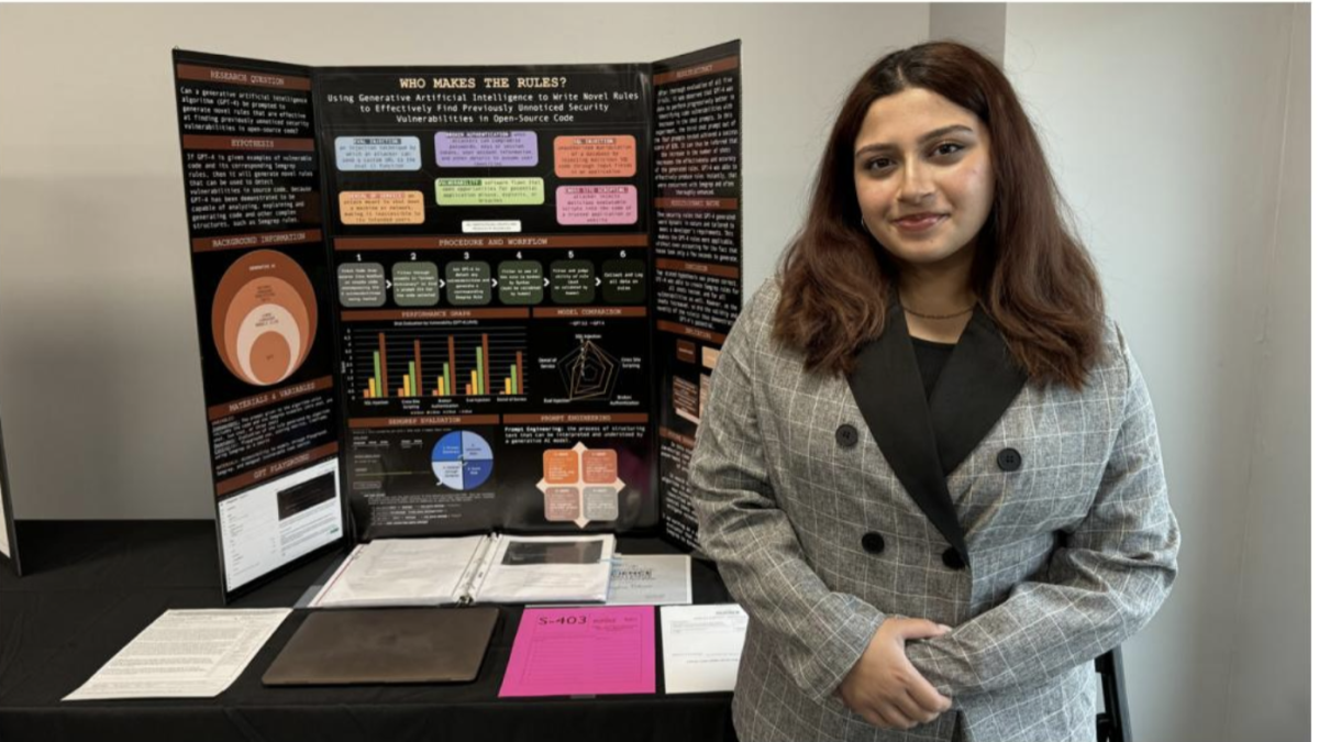 Junior+Meghna+Vikram+stands+in+front+of+her+research+at+the+BSides+Salt+Lake+City+conference.+After+10+months+of+research%2C+Vikram+qualified+for+the+International+Science+and+Engineering+Fair.